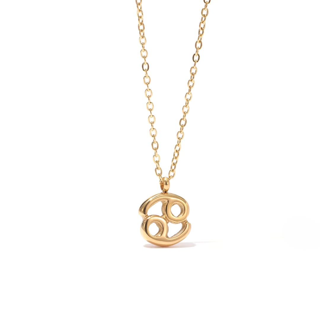 All 12 zodiac symbol bubble necklaces in 18K gold PVD displayed on a stone surface. Bold, chunky glyph pendants on delicate cable chains — waterproof and tarnish-free.